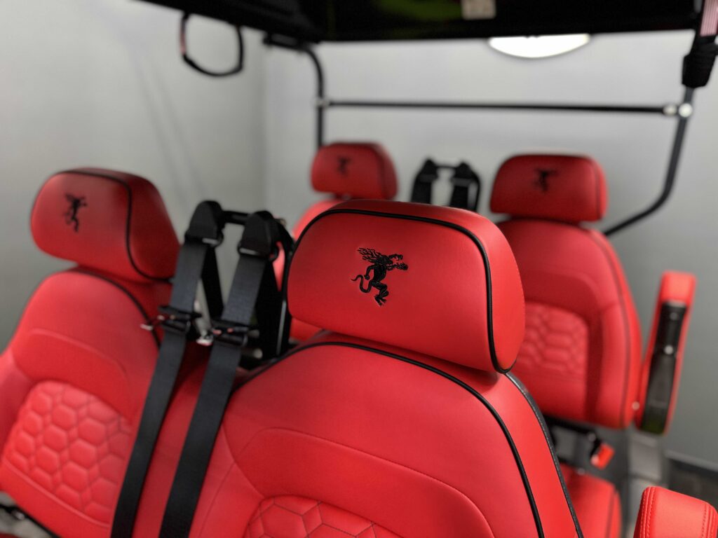 Custom embroidered Fireball dragon headrests on red leather golf cart seats by GOAT Custom Golf Carts