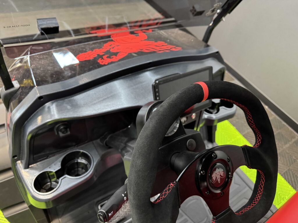 Custom steering wheel with red stitching and touch screen dash in the Fireball Whisky golf cart by GOAT Custom Golf Carts